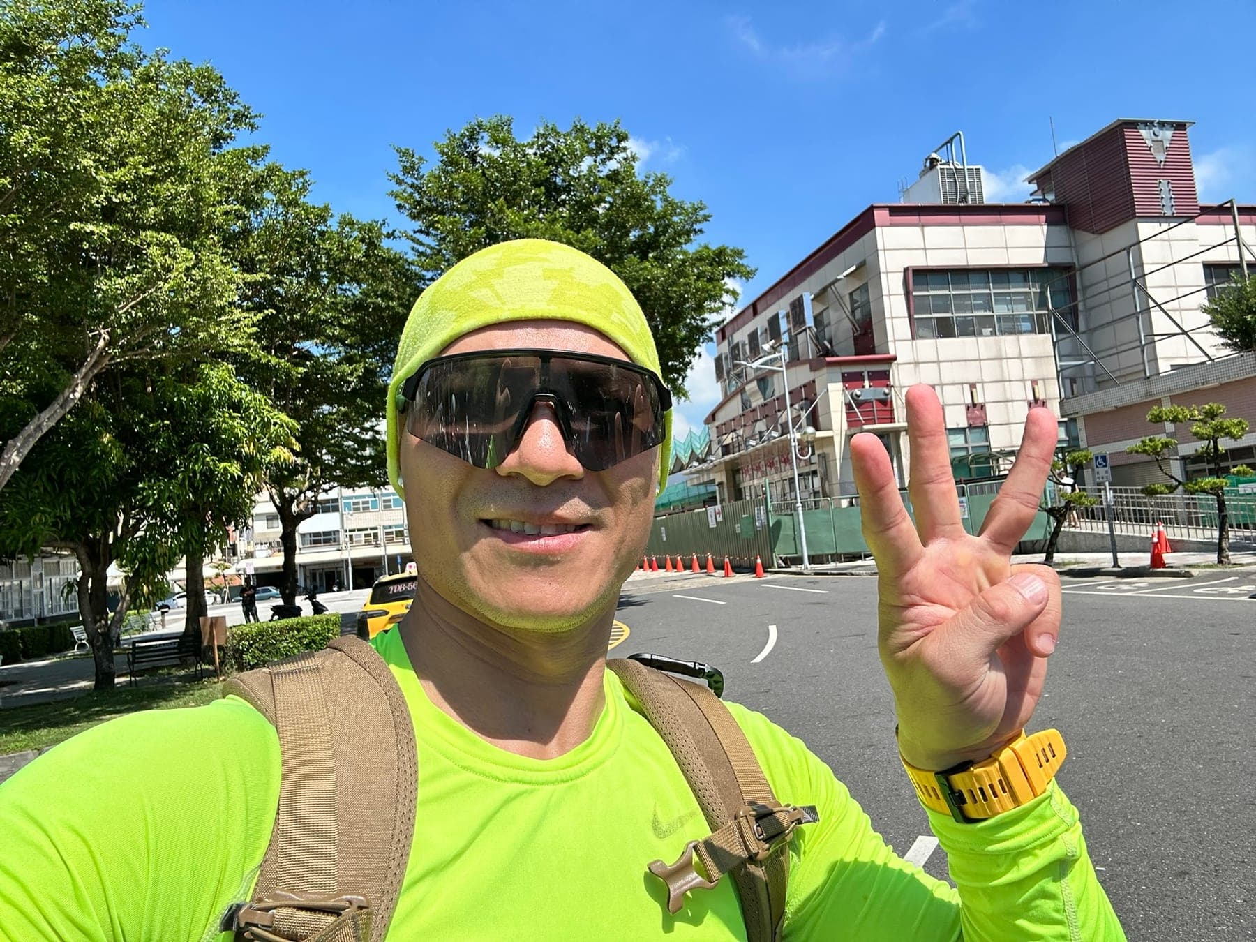 站主在田中車站前的走訪紀錄照,手比三代表第 3 站,站前有施工圍籬